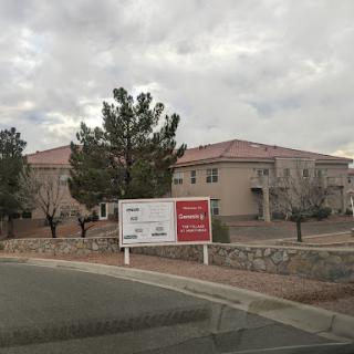 A view of residential buildings with a directional sign on a cloudy day.