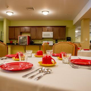A beautifully arranged dining table set with red plates and cups, showcasing a cozy restaurant interior.
