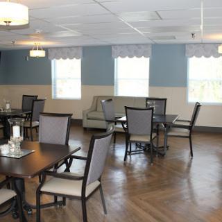 A spacious and well-lit dining area featuring elegant furniture and a cozy atmosphere.