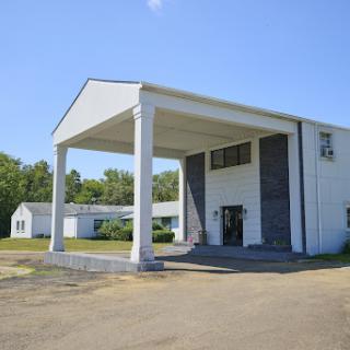 A modern architectural structure featuring prominent columns and a clear blue sky.
