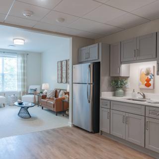 A modern apartment interior featuring an open-plan kitchen and living room with stylish furniture and decor.