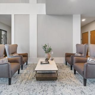 A modern lobby with comfortable chairs and a coffee table, featuring elegant decor.