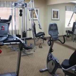 A small indoor gym with various exercise equipment including a treadmill and a stationary bike.