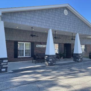 A modern commercial building featuring a stylish entrance with decorative triangular structures.