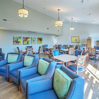 A modern lounge area with blue seating and decorative lighting.