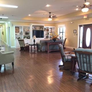A spacious and well-lit living room featuring comfortable furniture, a television, and elegant decor.