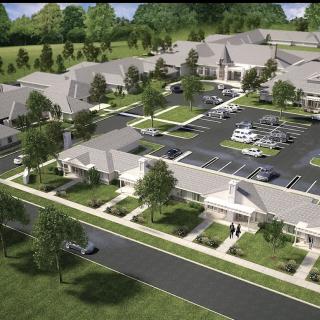 Aerial view of a residential complex with landscaped grounds and parking facilities.