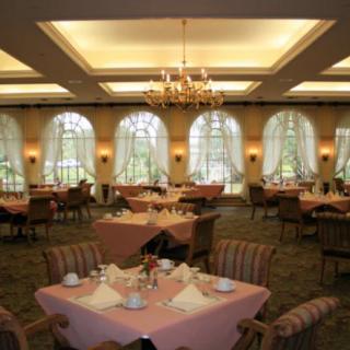 An elegant dining room with neatly arranged tables and chandeliers.