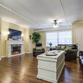 A modern living room featuring a fireplace, comfortable seating, and wood flooring.