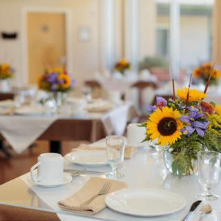 A beautifully arranged dining table featuring vibrant sunflowers and elegant tableware, perfect for a special event.