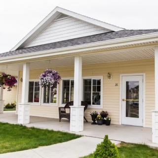 A charming house with a front porch and hanging plants.