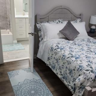 A cozy bedroom with floral bedding and a view into the adjacent bathroom.