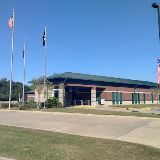 A view of a building with several flags under a clear blue sky.