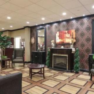 A stylish hotel lobby with modern furnishings, featuring elegant wallpaper, a fireplace, and artwork.