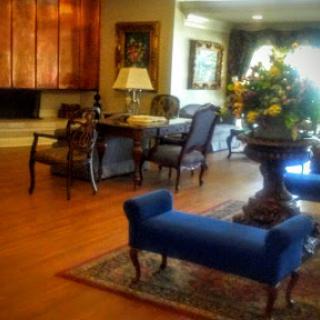 A cozy living room featuring elegant furniture and decorative floral arrangements.