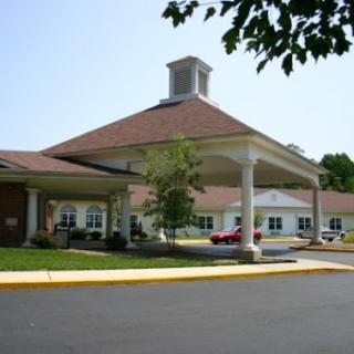 A welcoming senior living facility with a spacious entrance and landscaped surroundings.