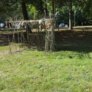 A rustic wooden structure surrounded by greenery in a park.