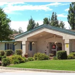 A suburban building surrounded by lush landscaping and trees.