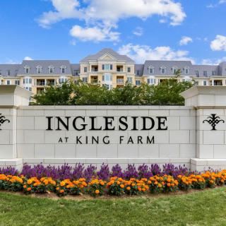 Entrance sign for Ingleside at King Farm with landscaped flowers and residential buildings in the background.