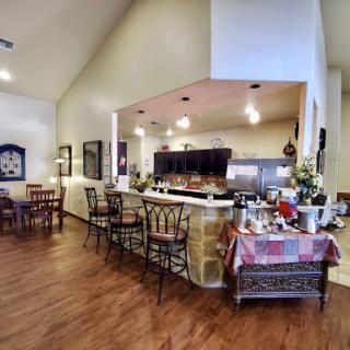 A welcoming dining area featuring a kitchen bar, wooden flooring, and a cozy setting for meals.
