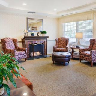 A cozy living room featuring armchairs, a fireplace, and a coffee table.