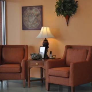 A cozy living room setup with two armchairs, a table, and a lamp.