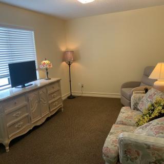 A cozy living room with a sofa, television, and lamps providing a warm ambiance.