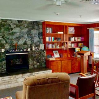 Cozy living room with a stone fireplace and wooden bookshelves.