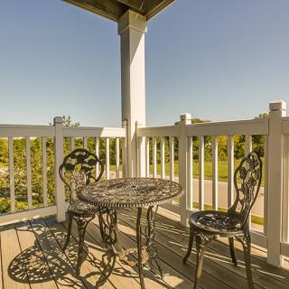 A sunny balcony with a wrought iron table and chairs set.