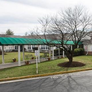 A suburban building with a covered walkway and landscaped lawn.
