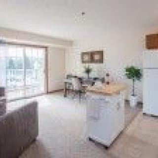 A bright apartment with an open living and dining area, featuring modern furniture and a view of the balcony.