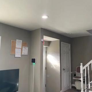 A well-lit living room with a staircase and wall decor.