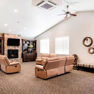 A spacious living room featuring comfortable seating, a fireplace, and a mounted television.