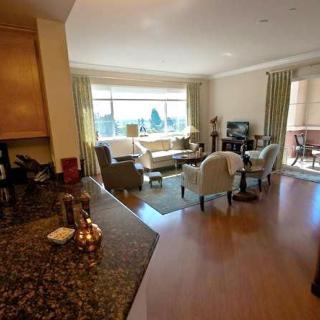 A cozy living room with ample natural light and comfortable furnishings.