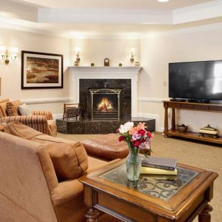 A cozy living room with a fireplace, comfortable sofa, and a large television.