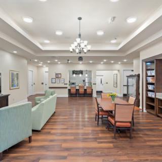 A spacious, modern living and dining area with elegant furnishings and wood flooring.