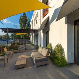 Modern outdoor patio with comfortable seating and sunshades.