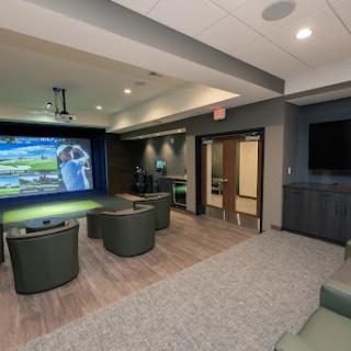 A modern lounge area featuring comfortable seating and a large projection screen for entertainment.