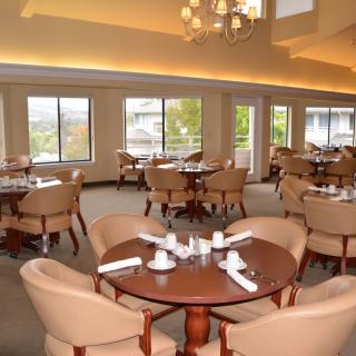 Elegant dining room with neatly arranged tables and chairs, offering a well-lit and welcoming atmosphere.