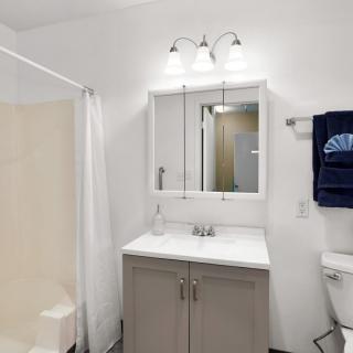A clean and modern bathroom with a mirror, sink, and shower.