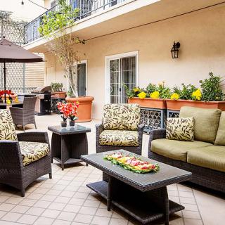 A cozy patio with stylish outdoor furniture and vibrant plant decorations.