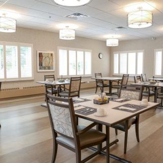 A spacious and modern dining room with neatly arranged tables and chairs.