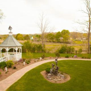 A tranquil garden with a gazebo and winding pathway surrounded by lush greenery.
