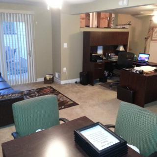 A well-organized home office with desks, chairs, and computer equipment.
