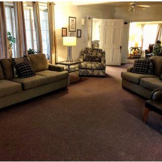 A cozy living room with sofas, an armchair, and a warm ambiance.