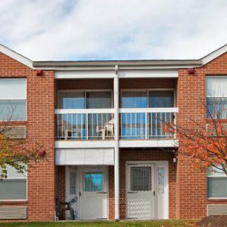 A two-story brick apartment building with balconies.
