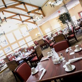 Elegant restaurant dining area with neatly set tables and warm lighting.