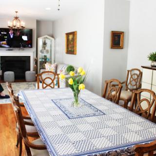 A beautifully arranged dining room featuring a large table with a floral centerpiece and comfortable seating.