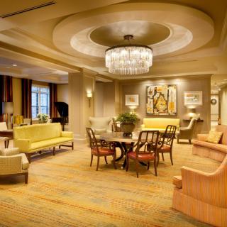A luxurious living room featuring elegant furniture and a chandelier.