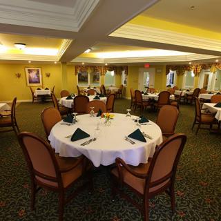 An elegant dining room with round tables set for a meal.